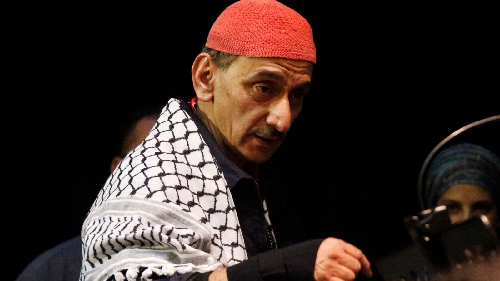 Ziad Rahbani in red skullcap with a keffiyeh over his shoulders