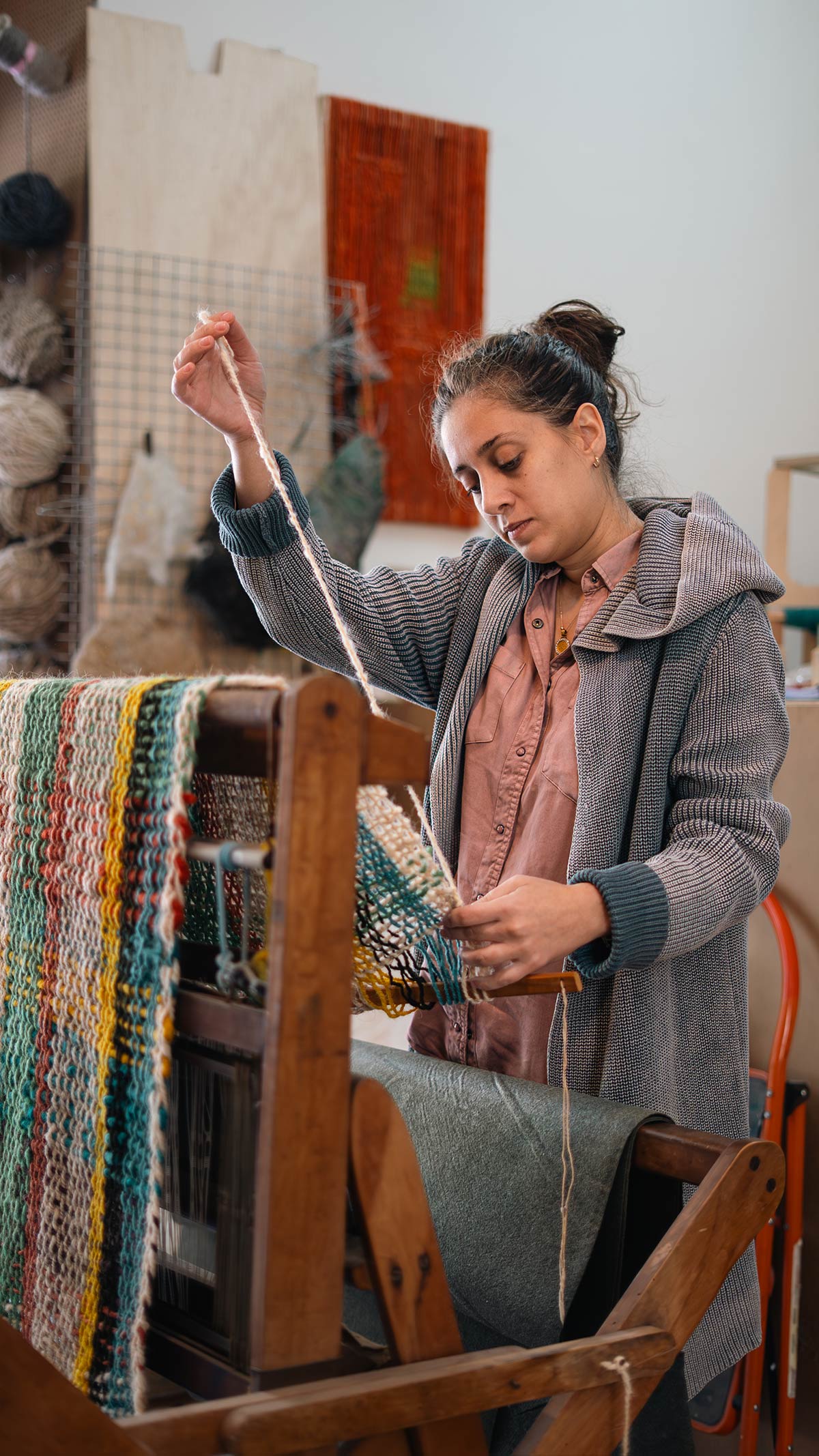 Lara finalizing a wool throw she wove on the loom.